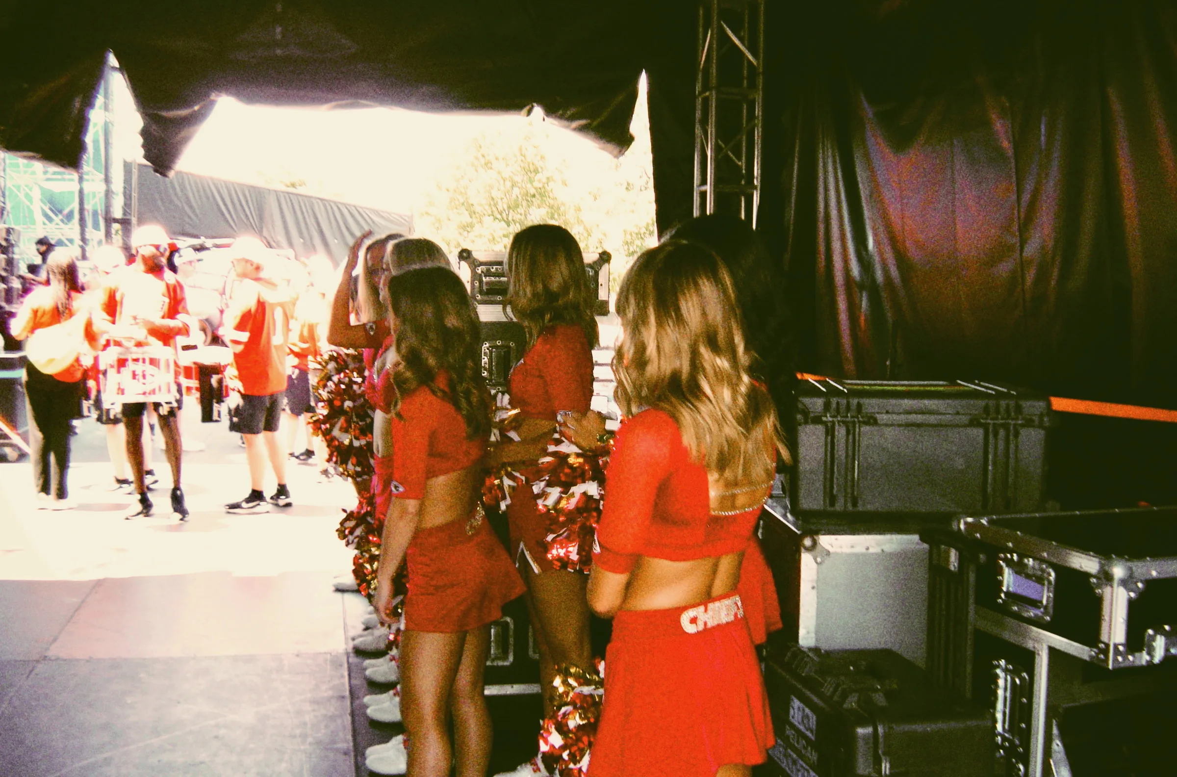 Performers waiting in the wings as the crowd moves past on the concourse beyond
