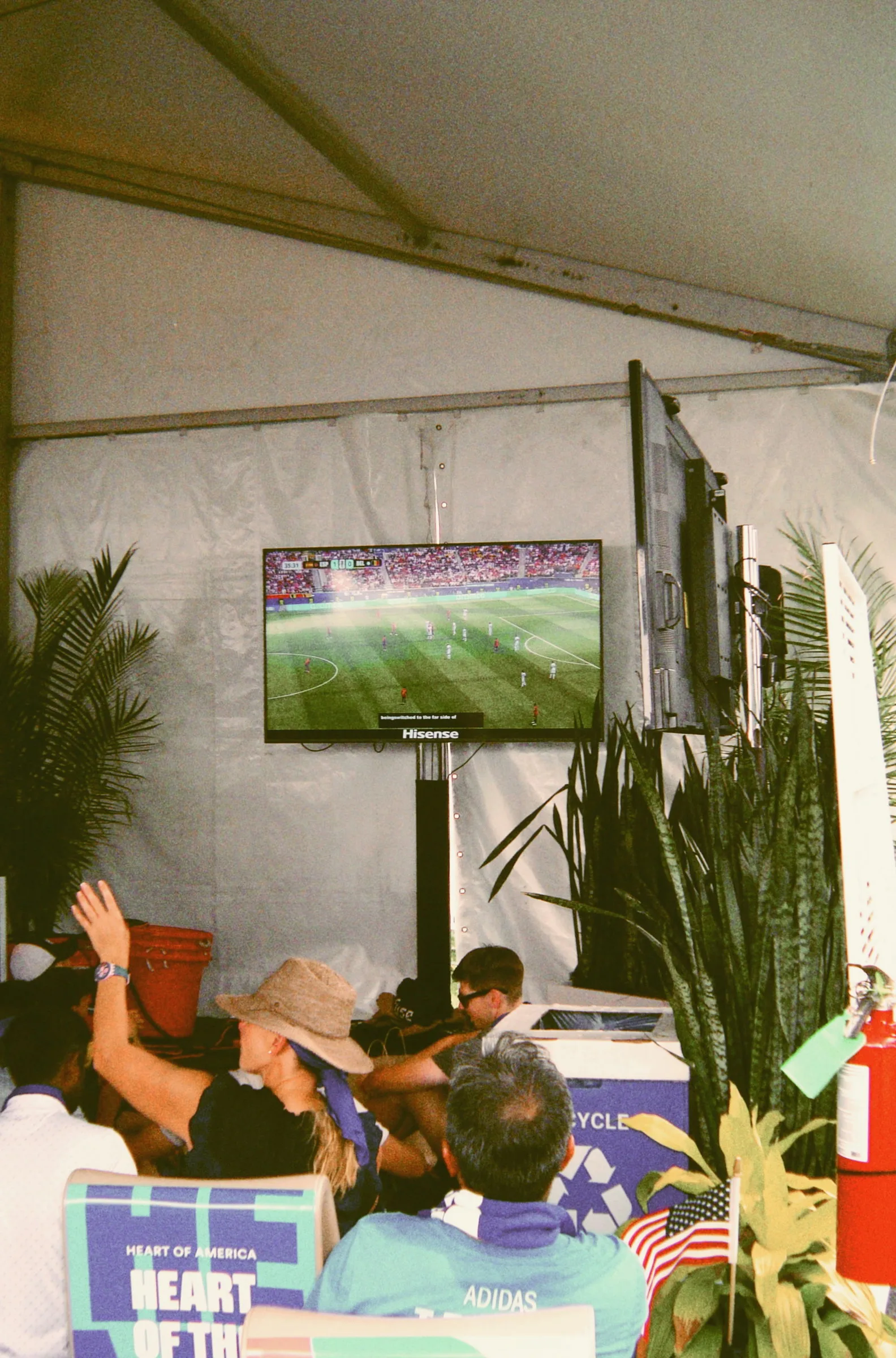 A wider view inside the marquee, a match playing on a screen above the heads of the crowd
