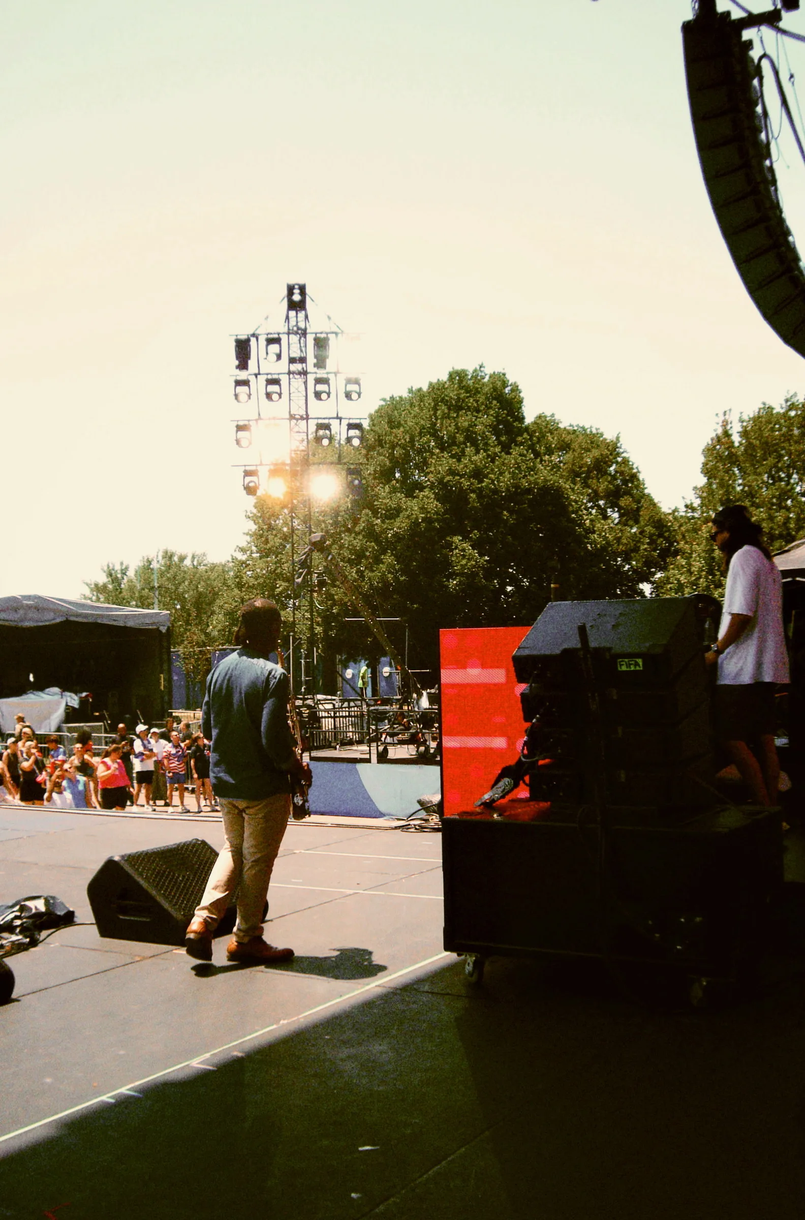 A lone figure standing at the edge of the stage in flat afternoon light