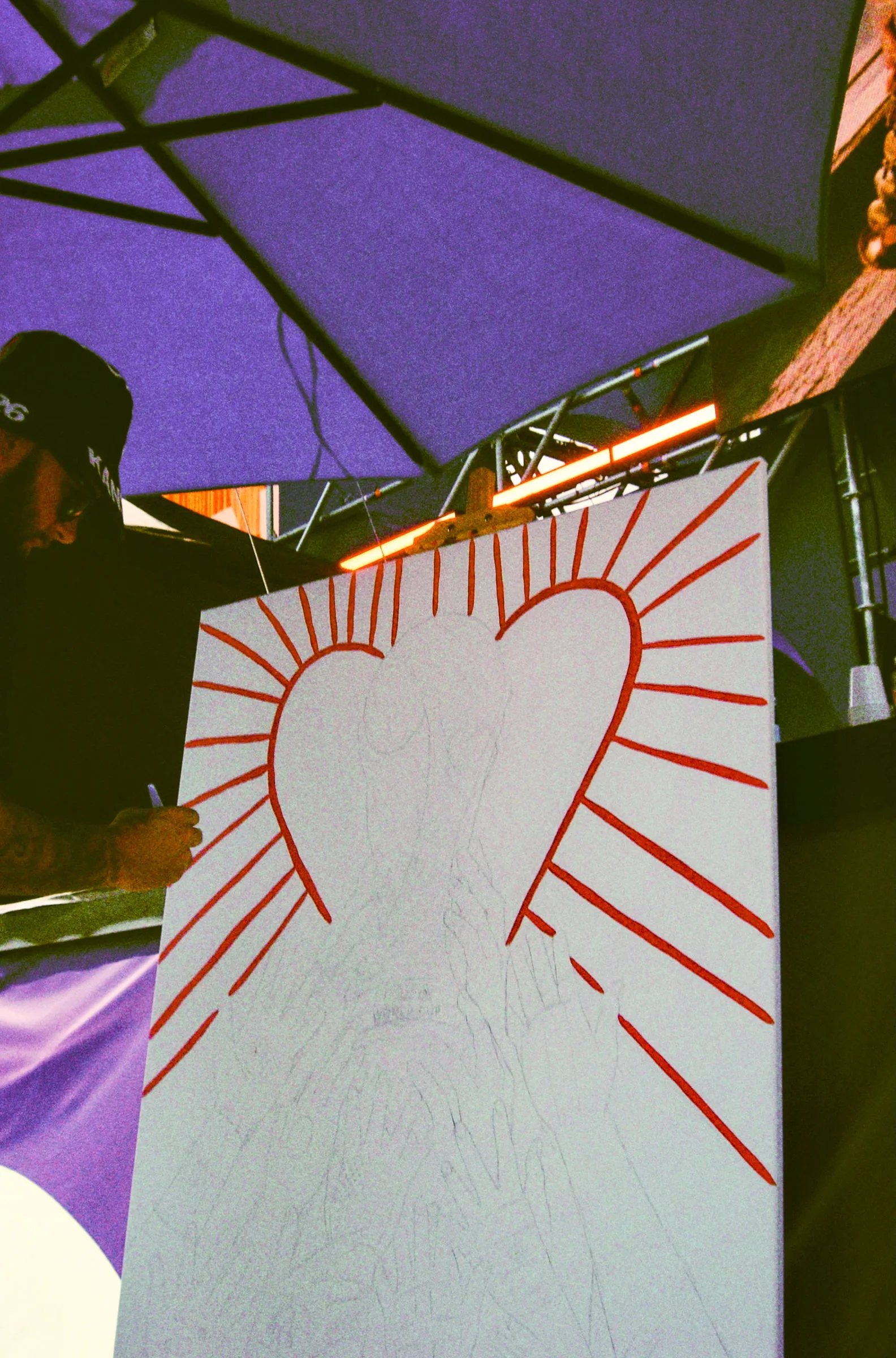 A heart drawn in red marker on a white board, rays coming off it